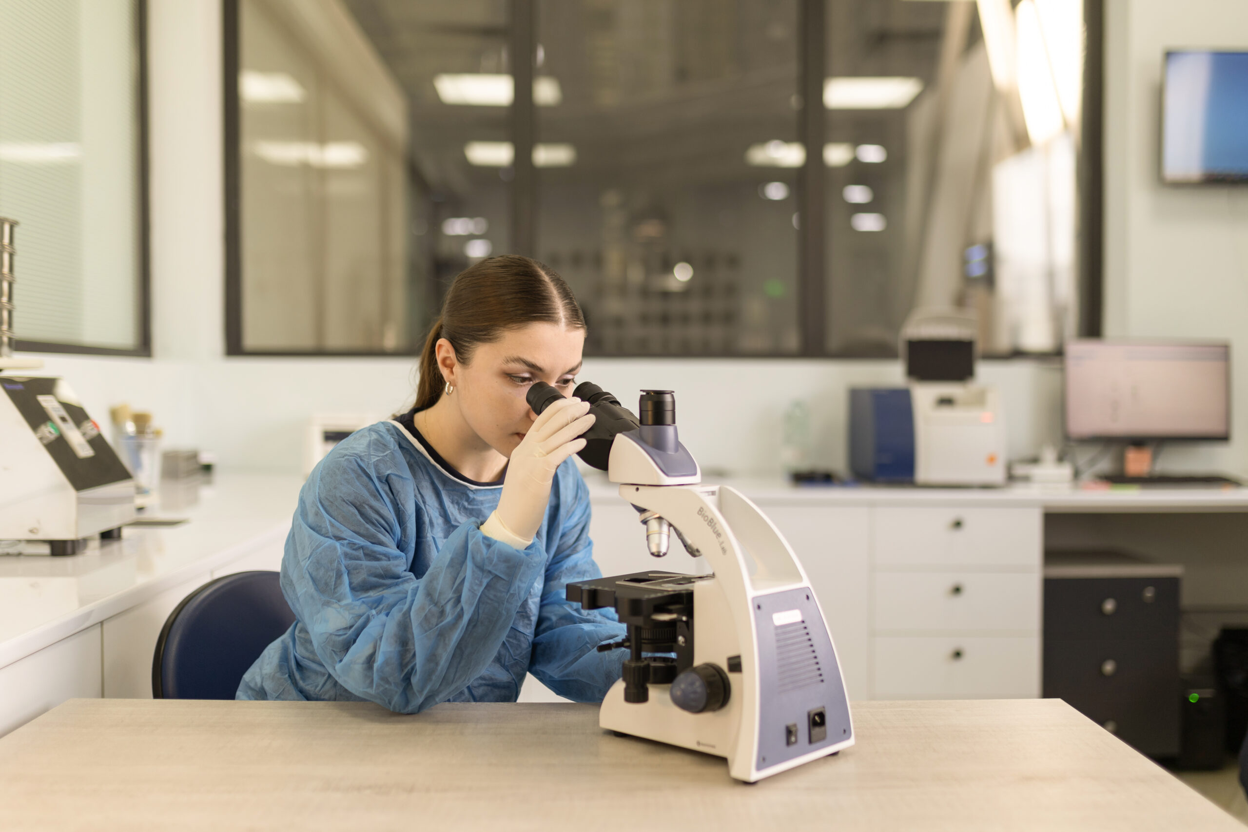 Female scientist in a lab coat using a microscope in a laboratory